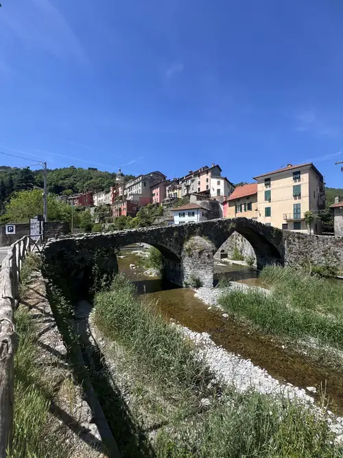 A stone bridge below a hillside village